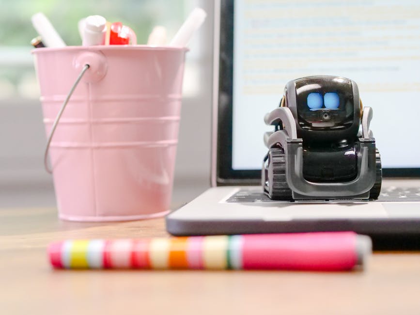 Black miniature robot on laptop keyboard